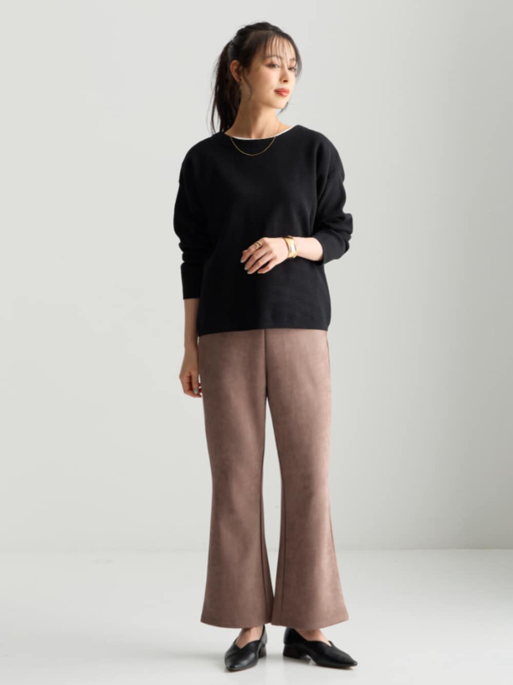 ブラック系のニット/セーター、ブラウン系のパンツを着用したレディースの秋コーディネートの1枚目の写真