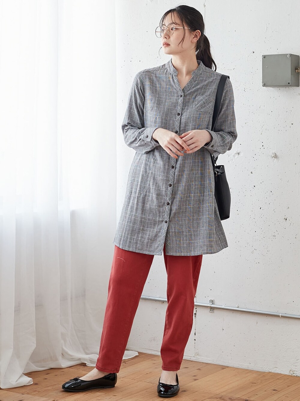 グレー系のチュニック、レッド系のデニムパンツ、ブラック系のバレエシューズを着用したレディースの夏コーディネートの1枚目の写真