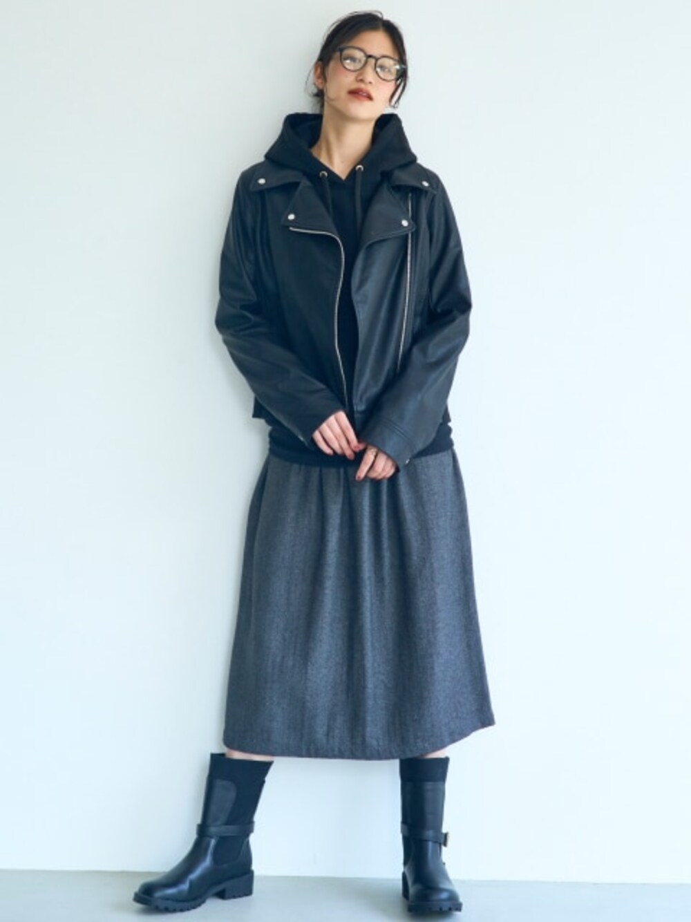 ブラック系のパーカー、ブラック系のジャケット/アウター、グレー系のスカートを着用したレディースの秋コーディネートの1枚目の写真
