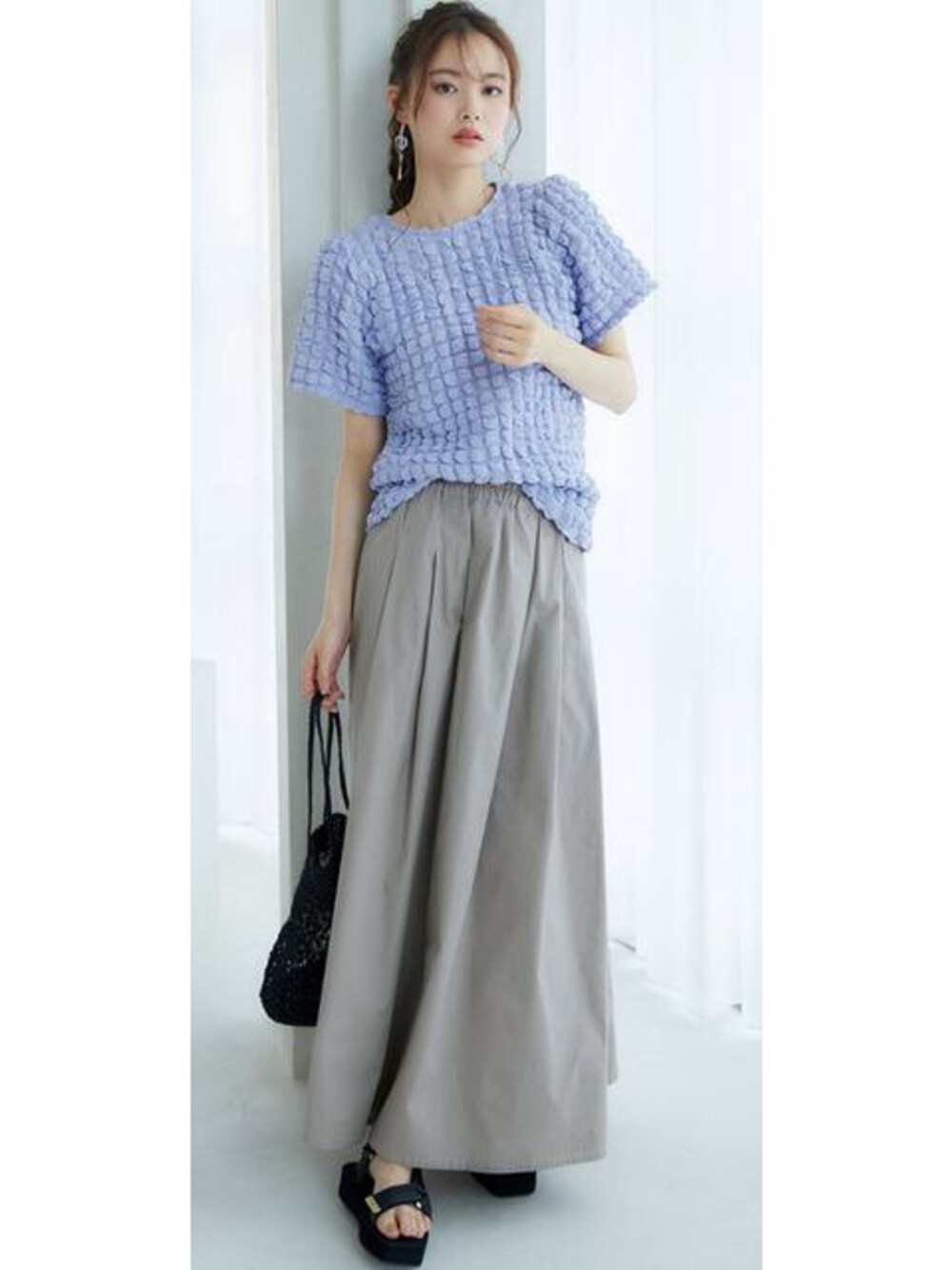 イエロー系のTシャツ/カットソー、グレー系のスカートを着用したレディースの春コーディネートの1枚目の写真