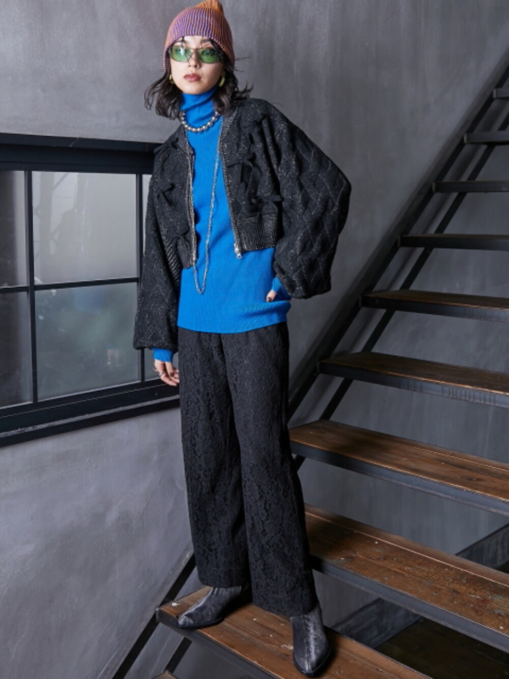 ブラック系のその他パンツ、ブルー系のニット/セーター、ブラック系のニット/セーターを着用したレディースの秋コーディネートの1枚目の写真