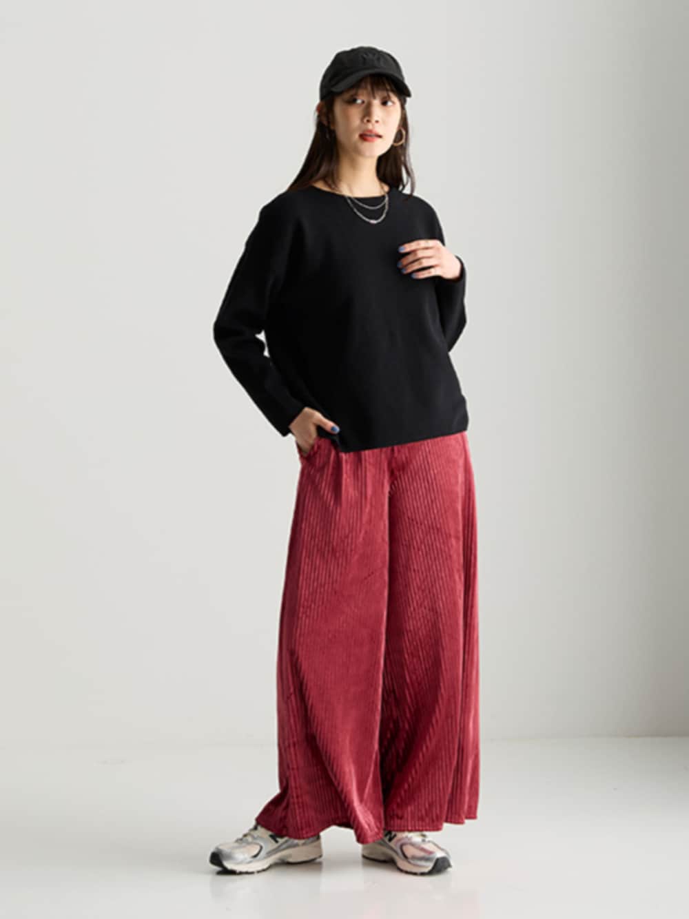 ブラック系のニット/セーター、レッド系のパンツを着用したレディースの秋コーディネートの1枚目の写真