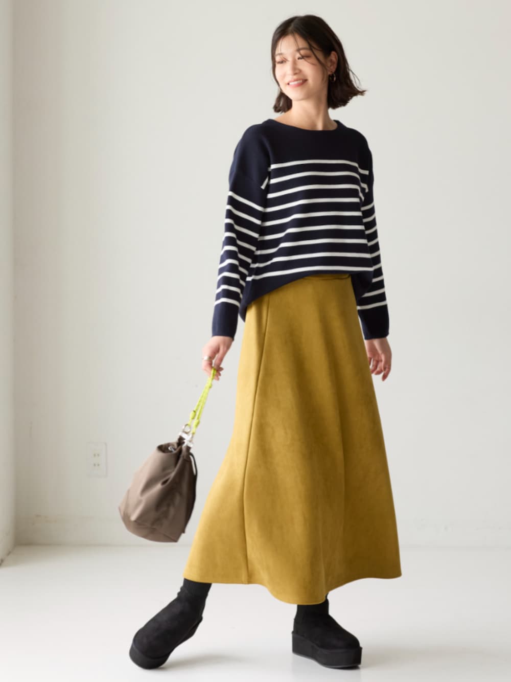 ブルー系のニット/セーター、イエロー系のスカートを着用したレディースの秋コーディネートの1枚目の写真