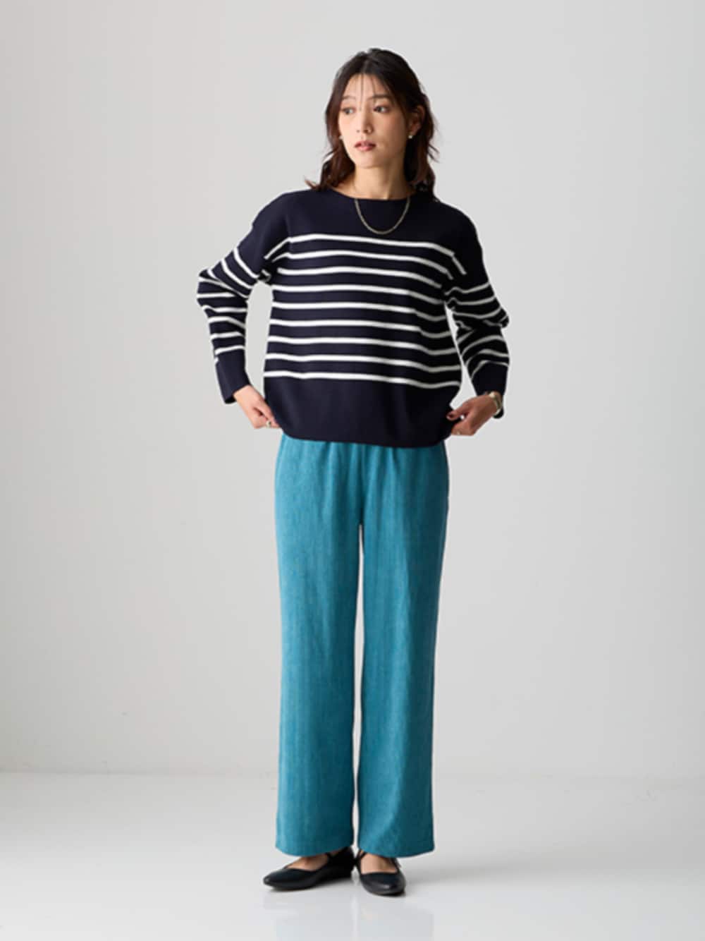 ブルー系のニット/セーター、ブルー系のパンツを着用したレディースの秋コーディネートの1枚目の写真