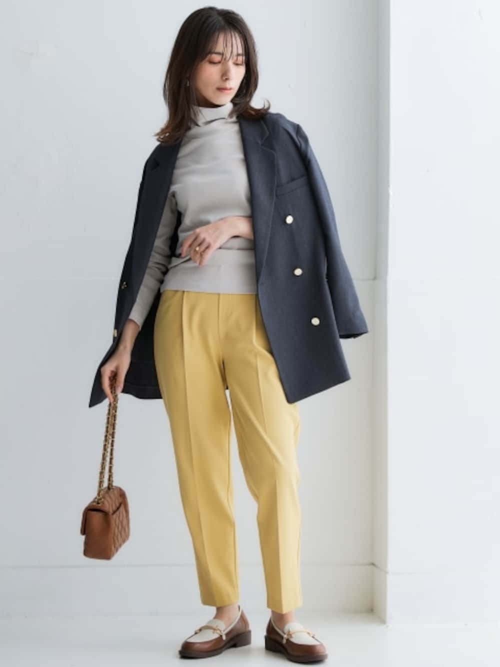 イエロー系のスラックス、グレー系のTシャツ/カットソー、グレー系のテーラードジャケットを着用したレディースの冬コーディネートの1枚目の写真