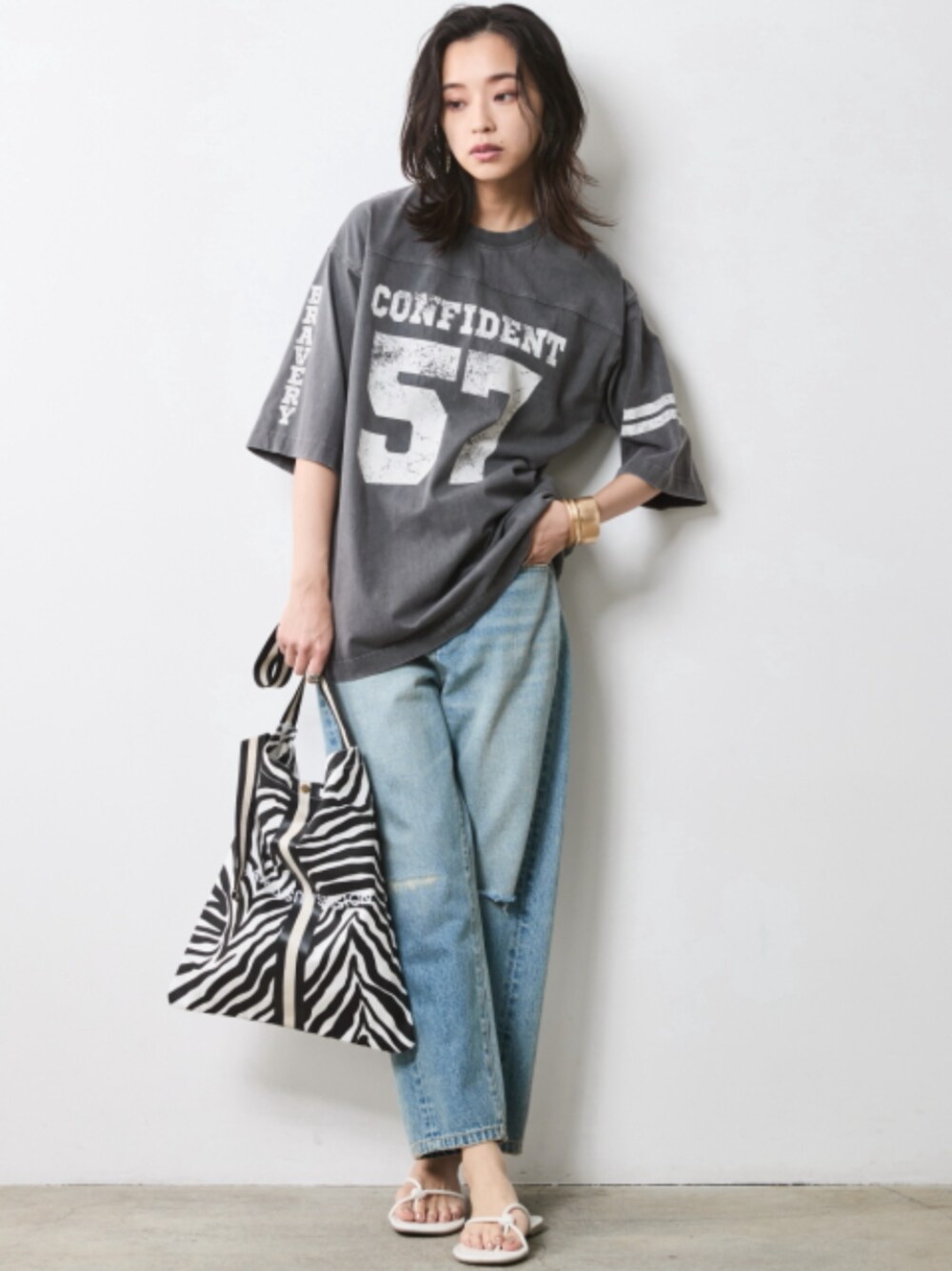 グレー系のTシャツ/カットソー、ブルー系のデニムパンツを着用したレディースの冬コーディネートの1枚目の写真