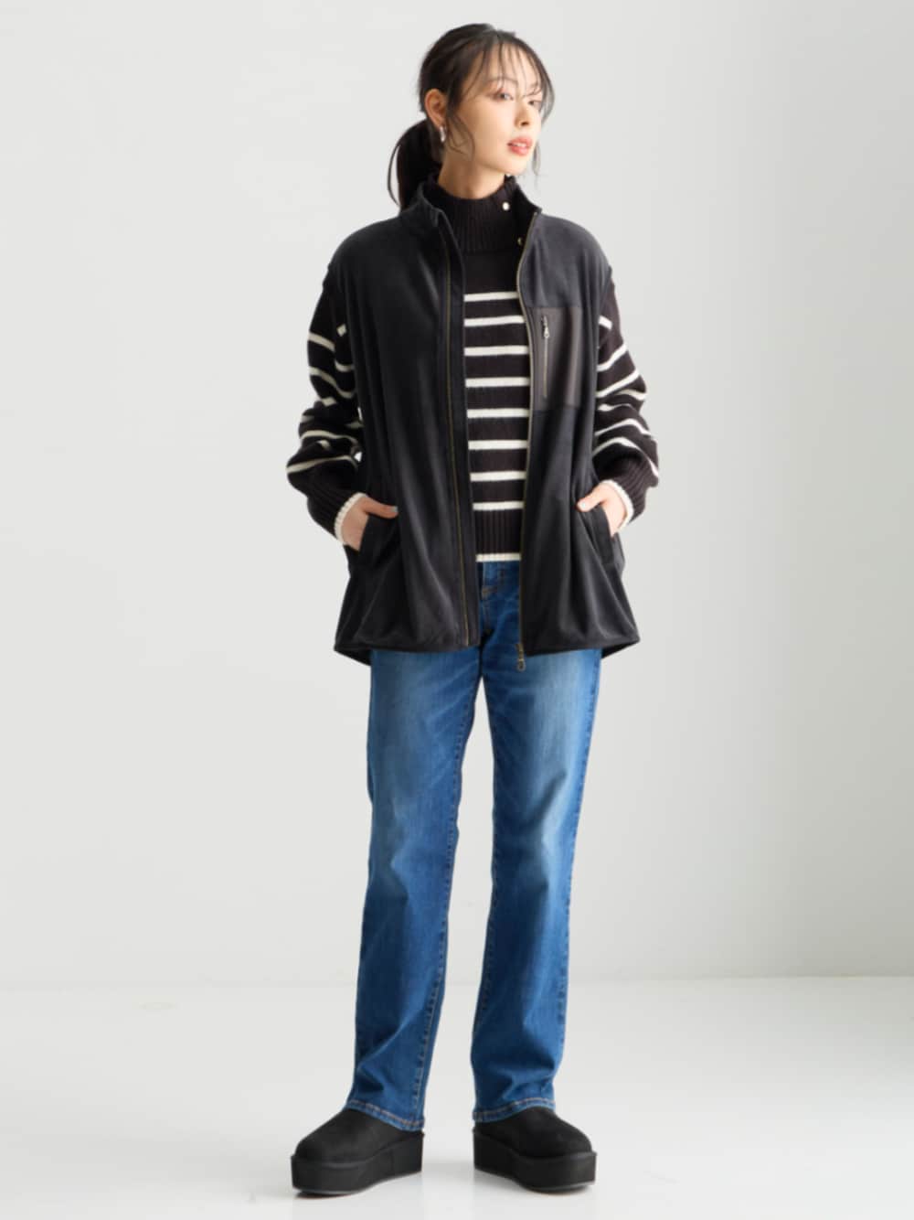 ブルー系のチノパンツ、ブラック系のベストを着用したレディースの秋コーディネートの1枚目の写真