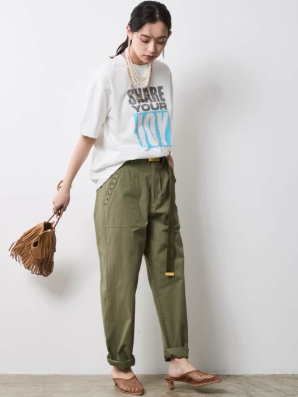 グリーン系のその他パンツ、ホワイト系のTシャツ/カットソー、グリーン系のベルトを着用したレディースの春コーディネートの1枚目の写真