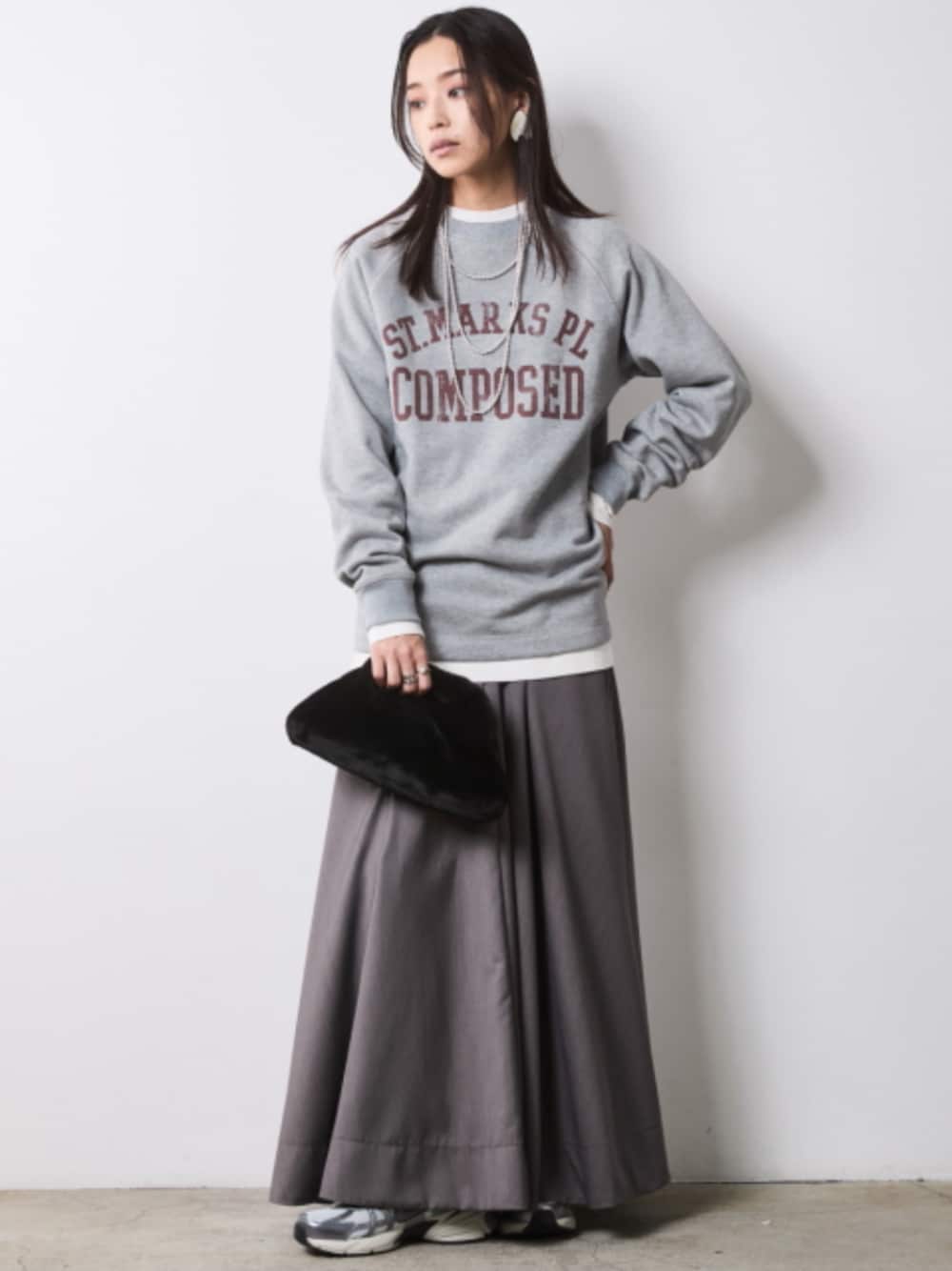 グレー系のスウェット、グレー系のスカートを着用したレディースの秋コーディネートの1枚目の写真