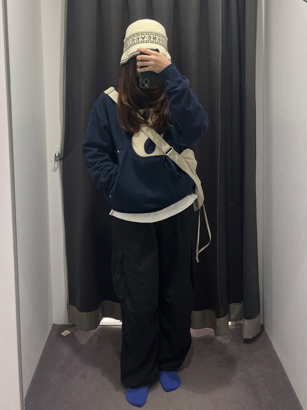 ブラック系のカーゴパンツ、ブルー系のパーカー、ベージュ系のショルダーバッグを着用したレディースの秋コーディネートの1枚目の写真