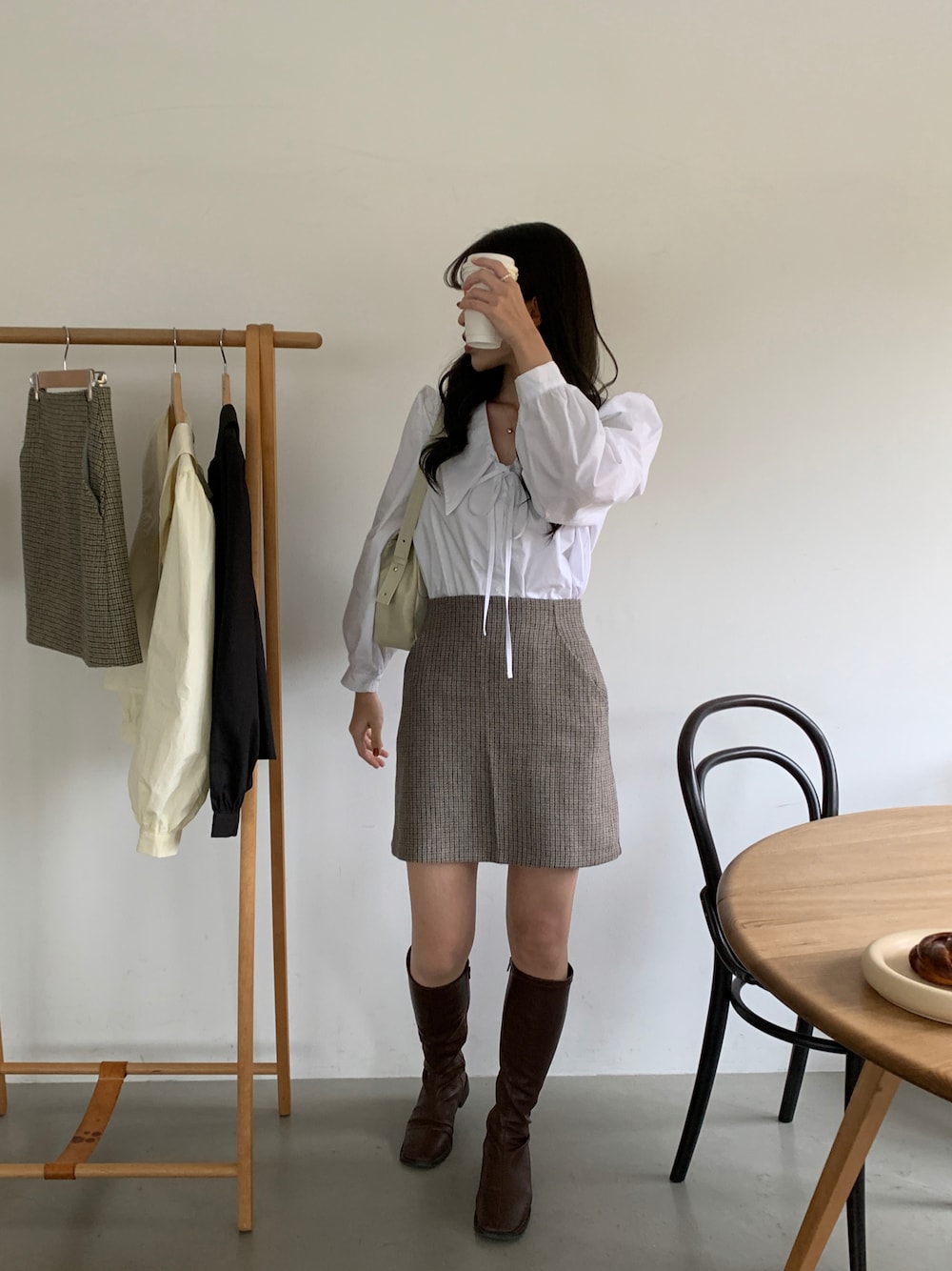 ホワイト系のシャツ/ブラウス、ブルー系のスカート、ブラウン系のブーツを着用したレディースの冬コーディネートの1枚目の写真