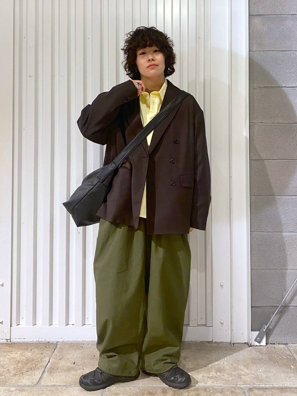 ブラック系のショルダーバッグ、ブラック系のスニーカー、ブラウン系のテーラードジャケットを着用したメンズの秋コーディネートの1枚目の写真