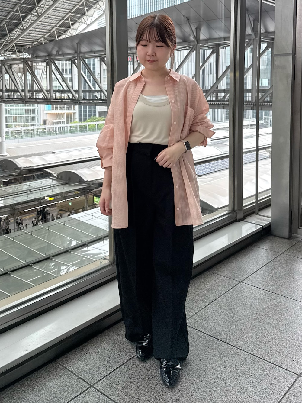 ベージュ系のタンクトップ、ブラック系のスラックス、ブラック系のローファーを着用したレディースの夏コーディネートの1枚目の写真