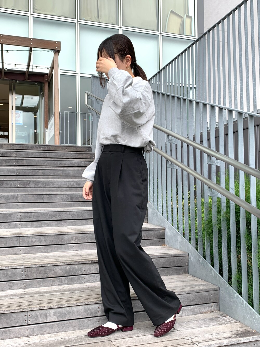 レッド系のパンプスを着用したレディースの秋コーディネートの1枚目の写真