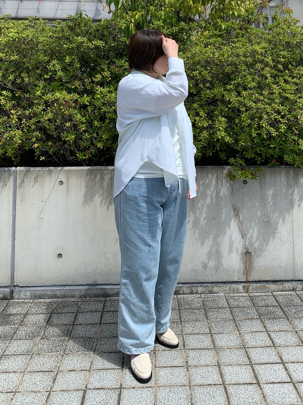 ホワイト系のパンプスを着用したレディースの春コーディネートの1枚目の写真