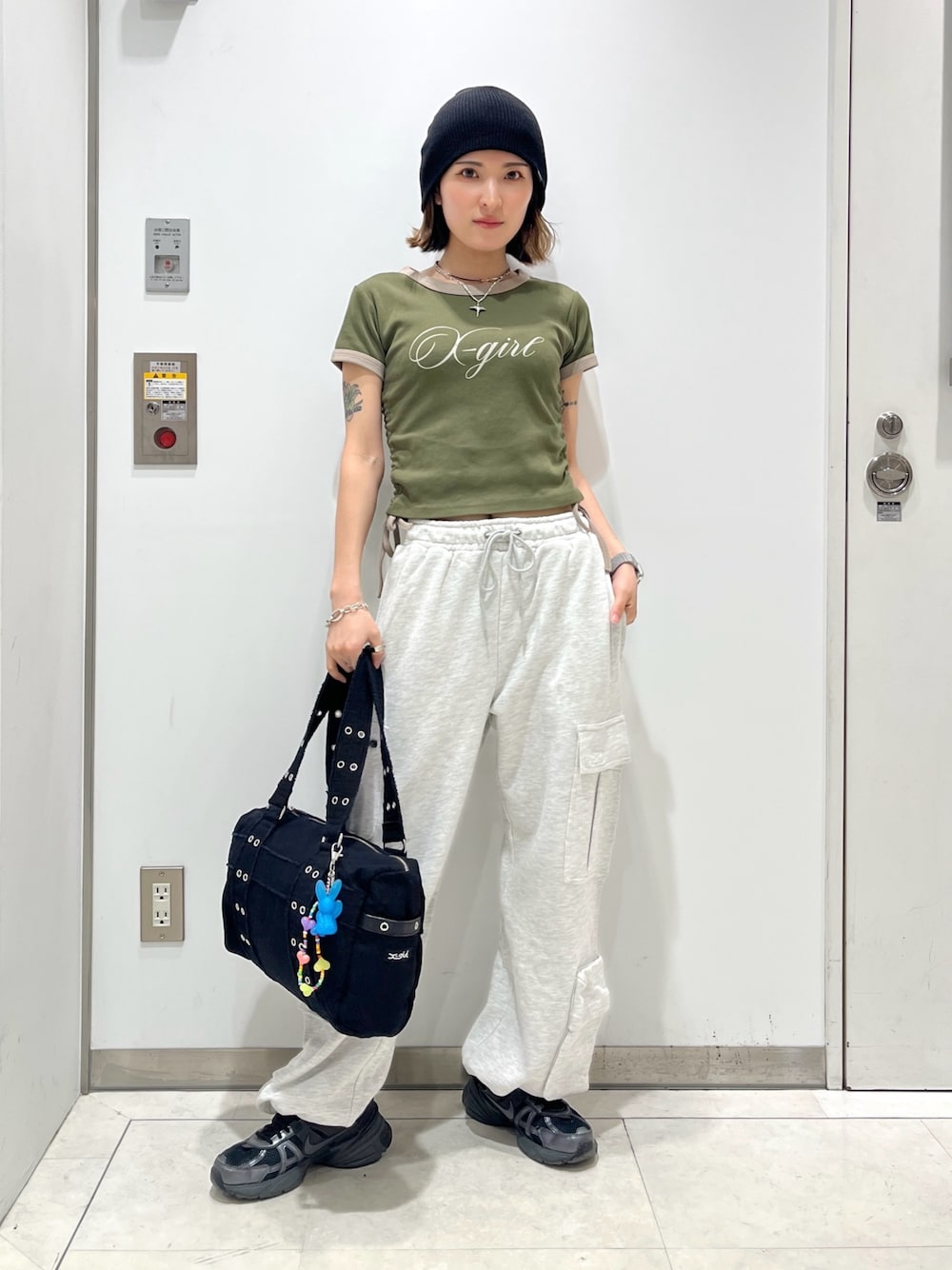 グレー系のスウェットパンツ、グリーン系のTシャツ/カットソー、ブラック系のハンドバッグを着用したレディースの春コーディネートの1枚目の写真