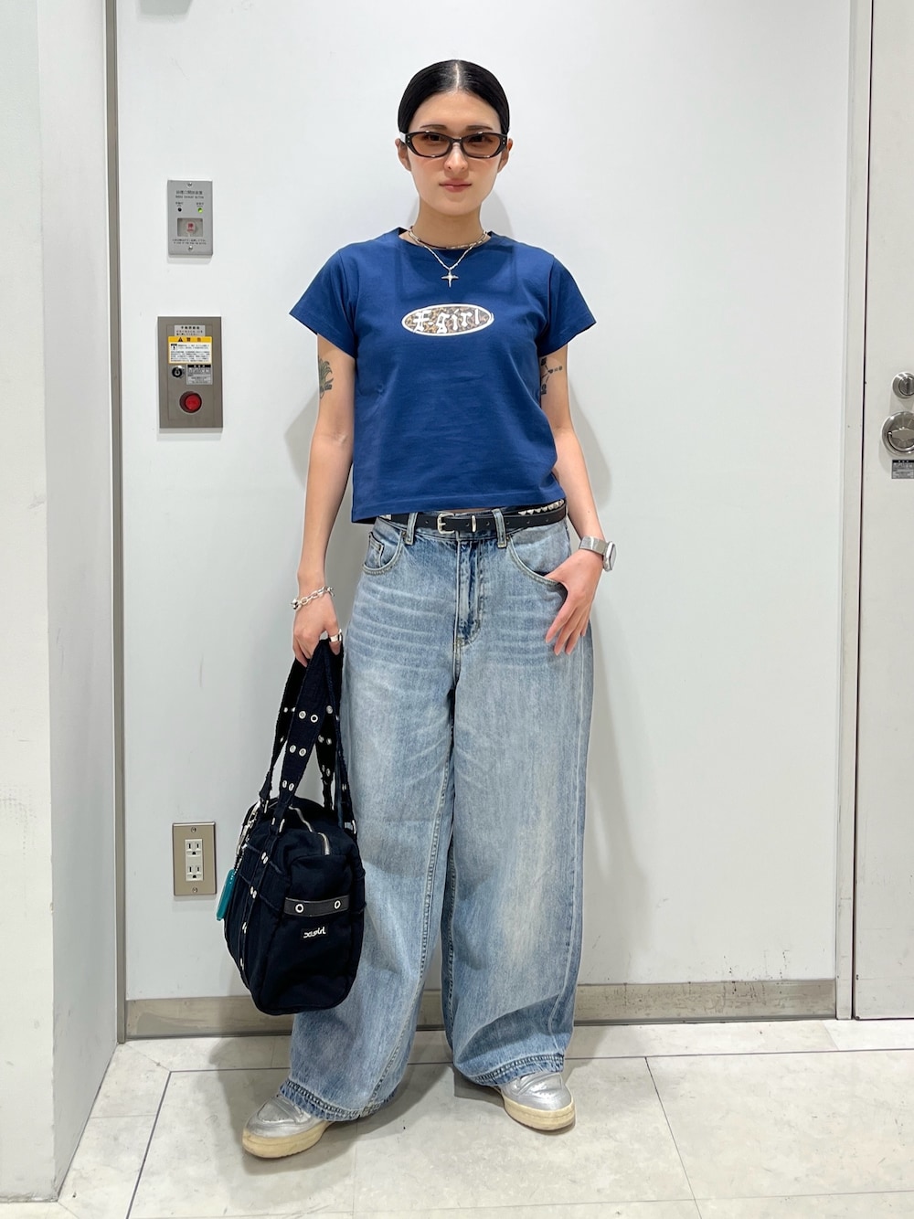 ブルー系のデニムパンツ、ブラック系のハンドバッグ、ブルー系のTシャツ/カットソーを着用したレディースの夏コーディネートの1枚目の写真
