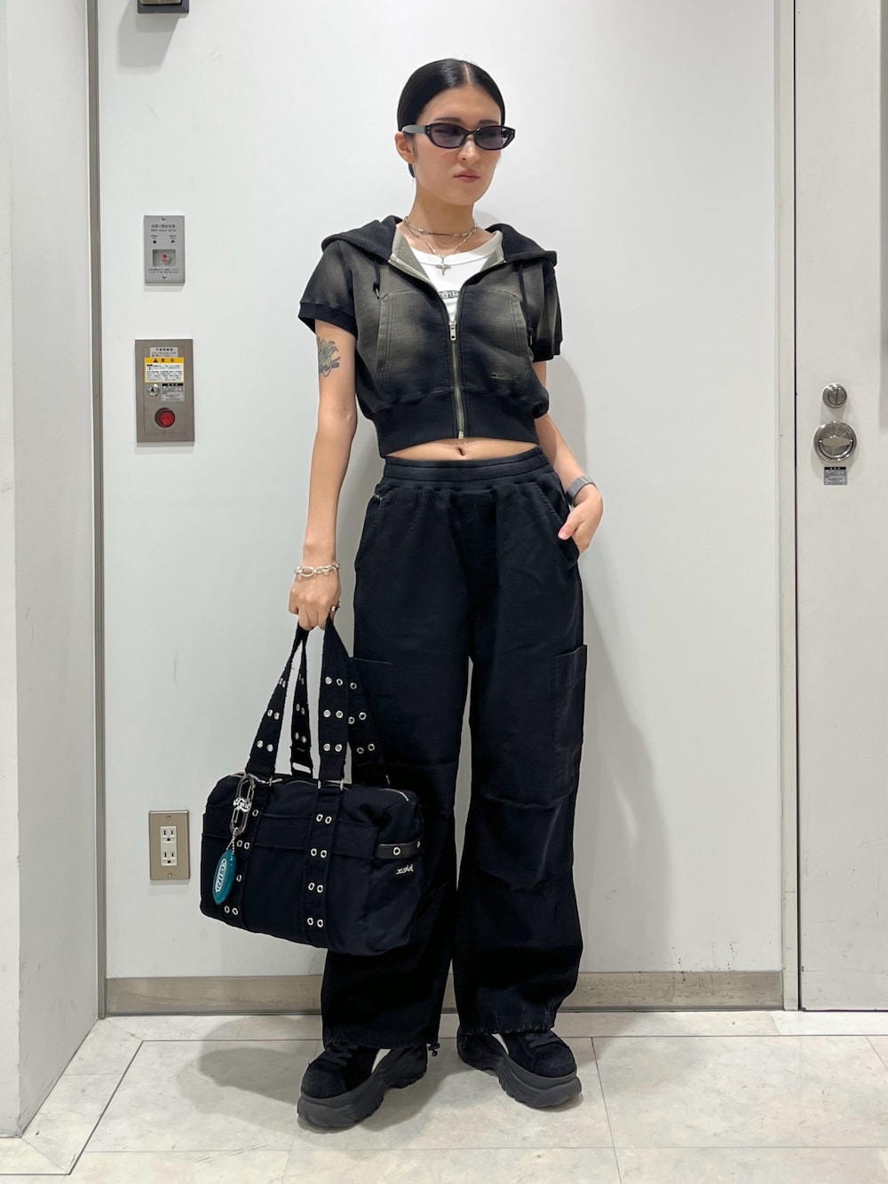 グリーン系のパーカー、ホワイト系のタンクトップ、ブラック系のその他パンツを着用したレディースの夏コーディネートの1枚目の写真