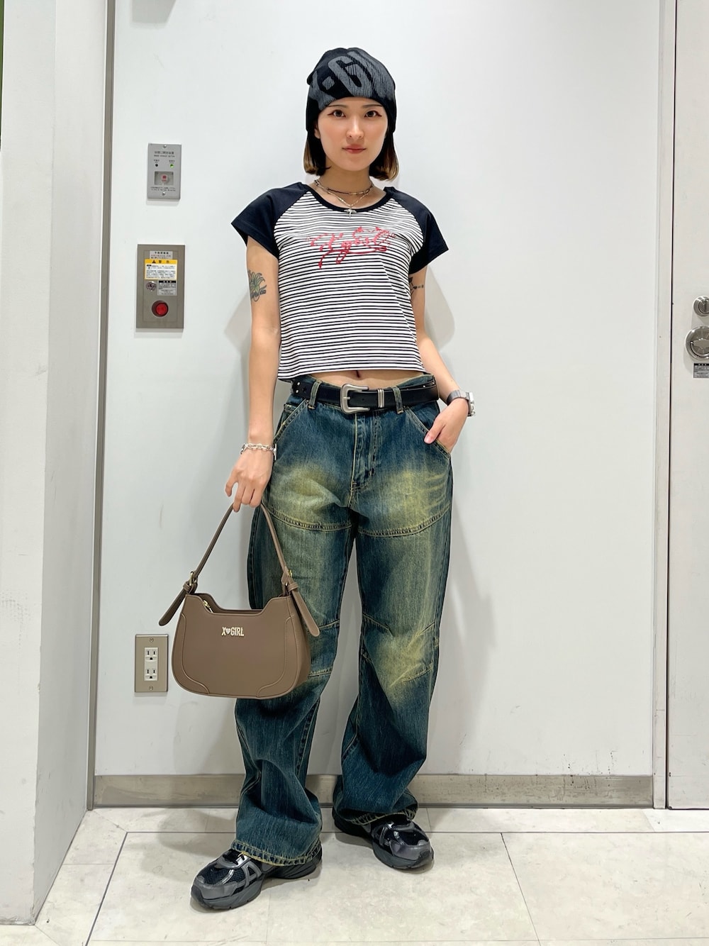 ブルー系のデニムパンツ、ホワイト系のTシャツ/カットソー、ベージュ系のハンドバッグを着用したレディースの夏コーディネートの1枚目の写真