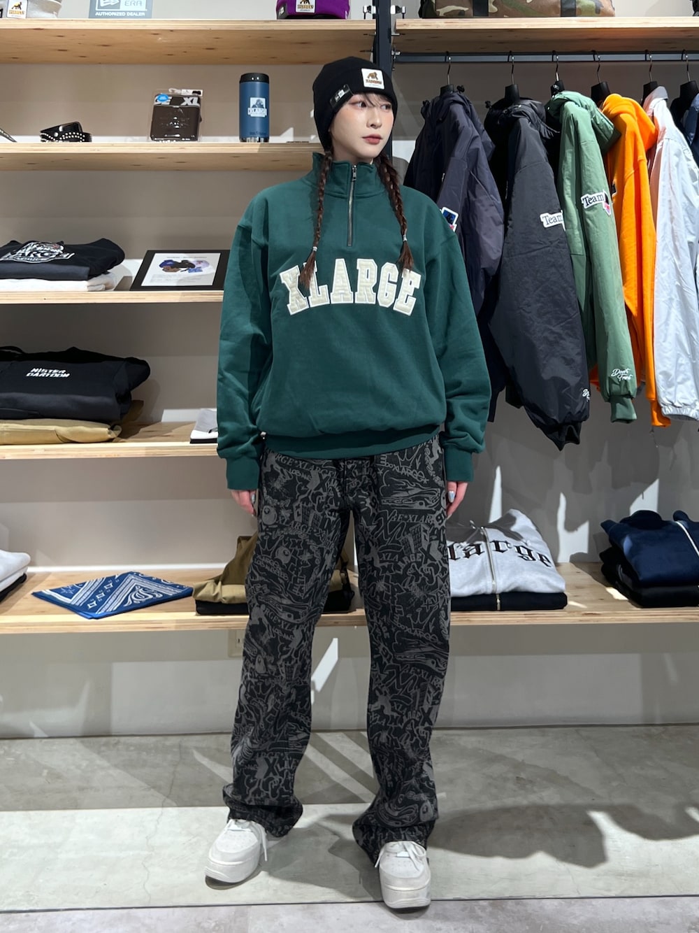 グリーン系のスウェット、ブラック系のデニムパンツ、ブラック系のニットキャップ/ビーニーを着用したレディースの冬コーディネートの1枚目の写真