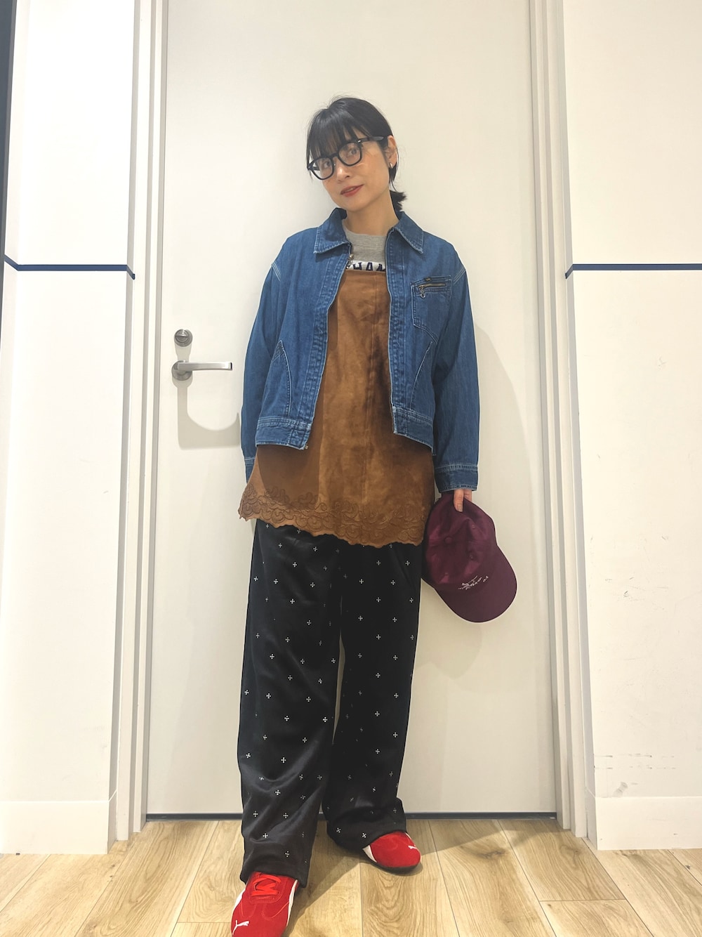ブラック系のその他パンツ、レッド系のスニーカー、ブルー系のデニムジャケットを着用したレディースの秋コーディネートの1枚目の写真