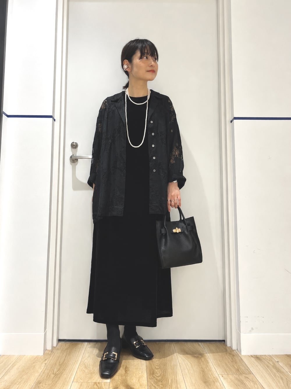 ブラック系のパンプス、ブラック系のハンドバッグ、ブラック系のシャツ/ブラウスを着用したレディースの秋コーディネートの1枚目の写真