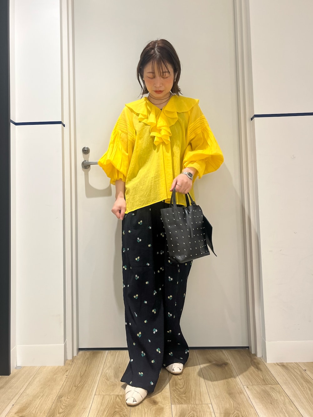 ブラック系のトートバッグ、ブルー系のその他パンツ、ホワイト系のパンプスを着用したレディースの春コーディネートの1枚目の写真