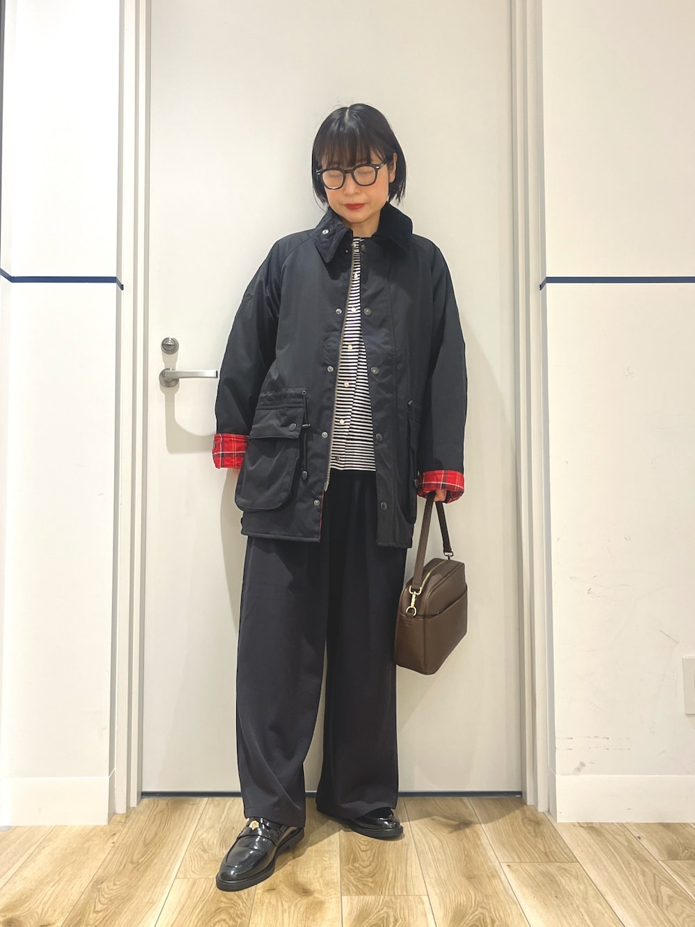 ブラック系のその他アウター、ホワイト系のカーディガン/ボレロ、ブラウン系のショルダーバッグを着用したレディースの秋コーディネートの1枚目の写真