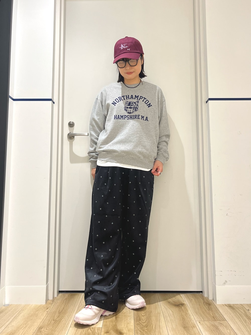 ピンク系のスニーカー、グレー系のスウェット、ホワイト系のTシャツ/カットソーを着用したレディースの秋コーディネートの1枚目の写真