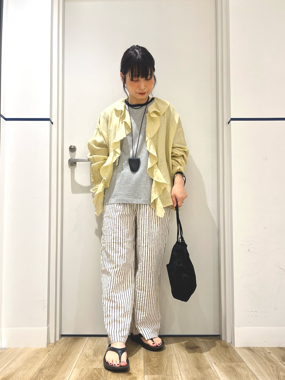 ブラック系のサンダル、ホワイト系のその他パンツ、ブラック系のバッグを着用したレディースの夏コーディネートの1枚目の写真