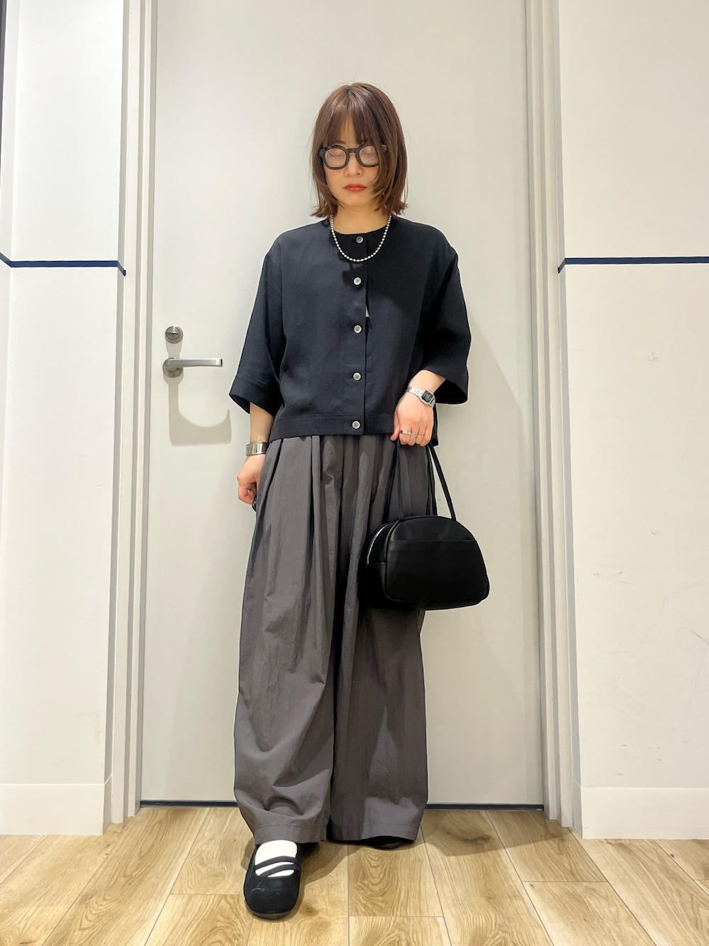 ブラック系のボストンバッグ、ブラック系のシャツ/ブラウス、グレー系のその他パンツを着用したレディースの春コーディネートの1枚目の写真