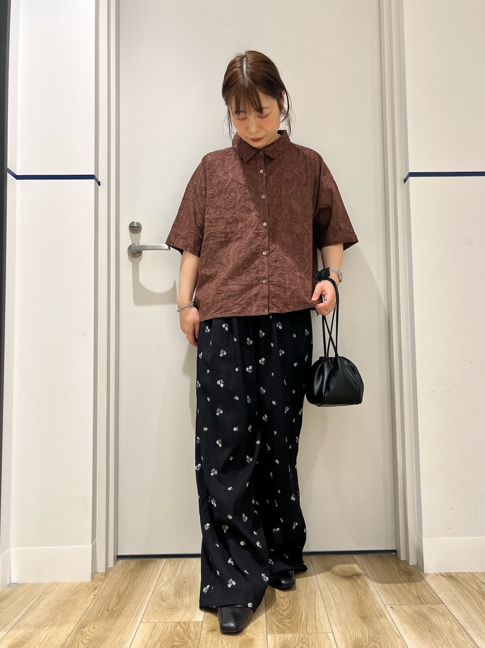 ブラウン系のシャツ/ブラウス、ブラック系のショルダーバッグ、ブルー系のその他パンツを着用したレディースの春コーディネートの1枚目の写真