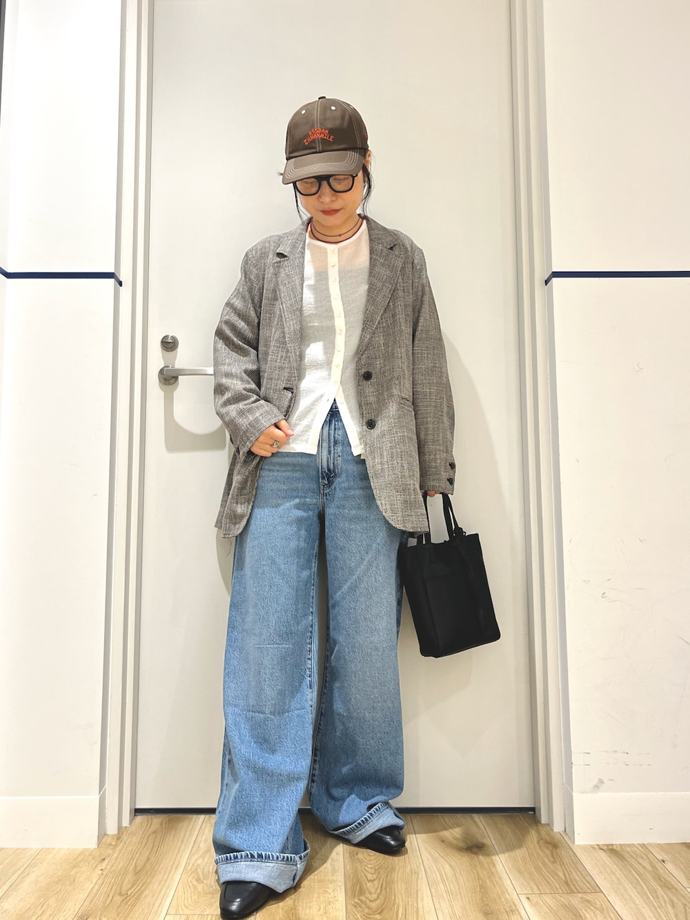 グレー系のその他アウター、ブルー系のデニムパンツ、ブラック系のトートバッグを着用したレディースの秋コーディネートの1枚目の写真