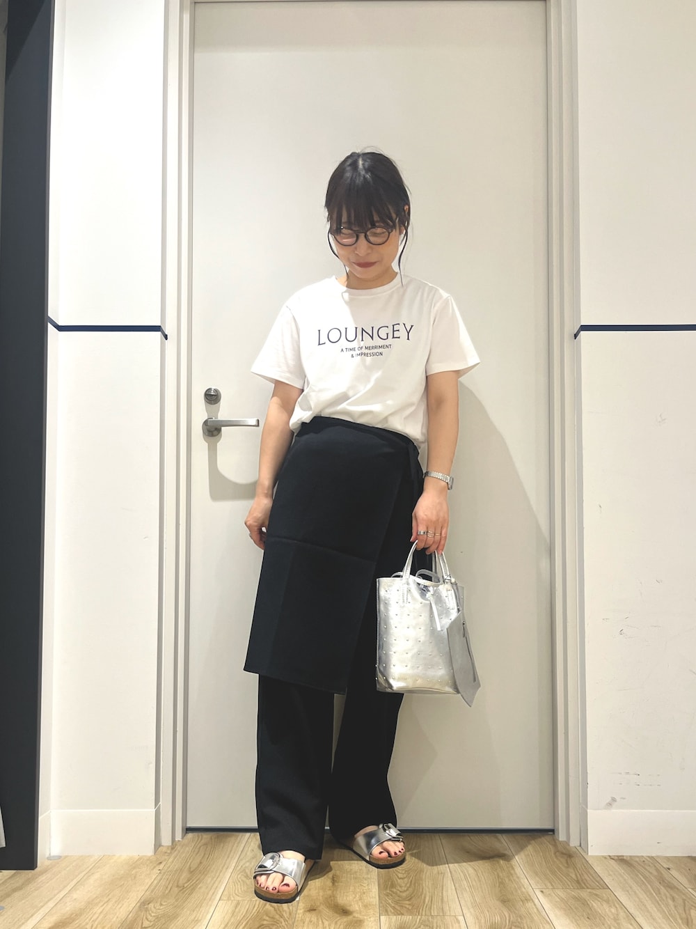 シルバー系のトートバッグ、ブラック系のその他パンツ、シルバー系のサンダルを着用したレディースの夏コーディネートの1枚目の写真