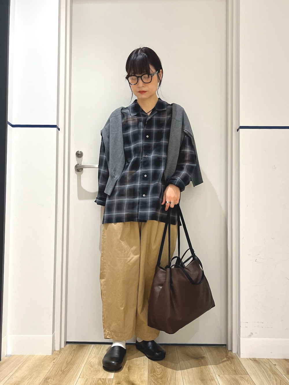 グレー系のカーディガン/ボレロ、ベージュ系のその他パンツ、ブラウン系のトートバッグを着用したレディースの秋コーディネートの1枚目の写真
