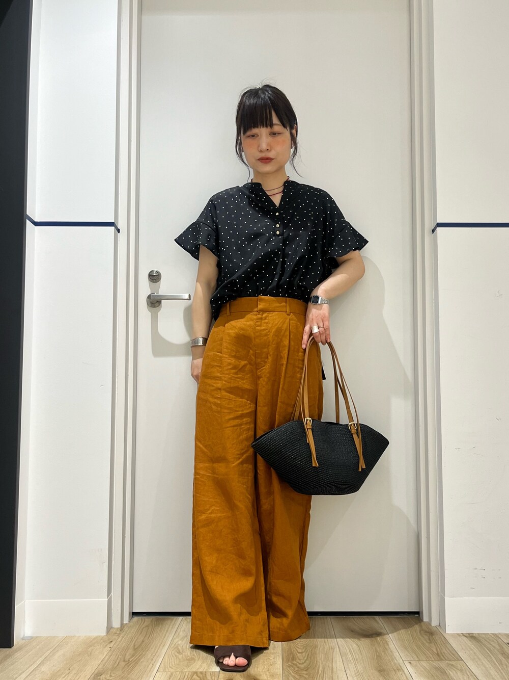 ブラウン系のサンダル、ブラック系のかごバッグ、ブラウン系のその他パンツを着用したレディースの夏コーディネートの1枚目の写真