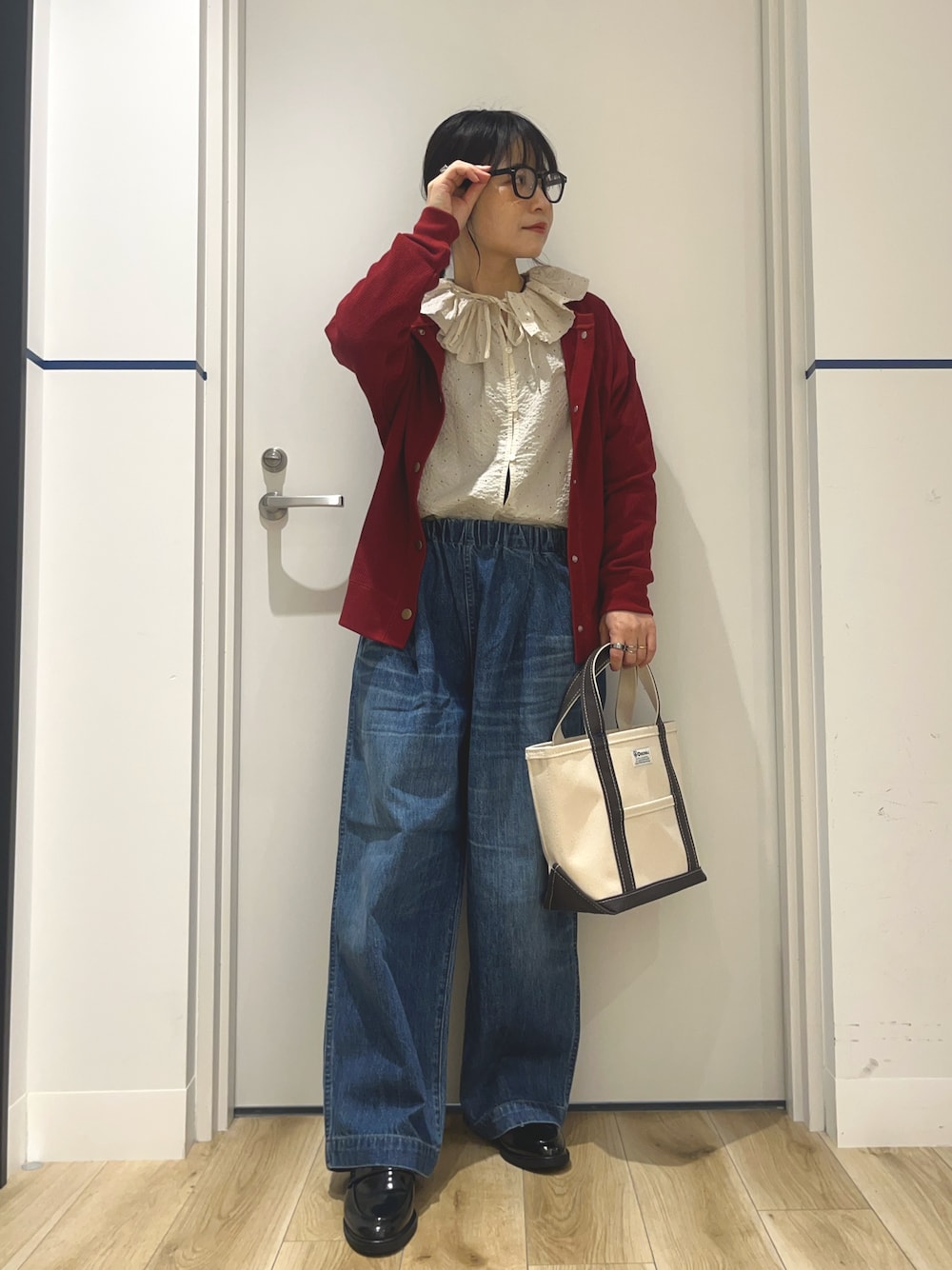 ブルー系のデニムパンツ、ブラック系のローファー、グレー系のトートバッグを着用したレディースの秋コーディネートの1枚目の写真