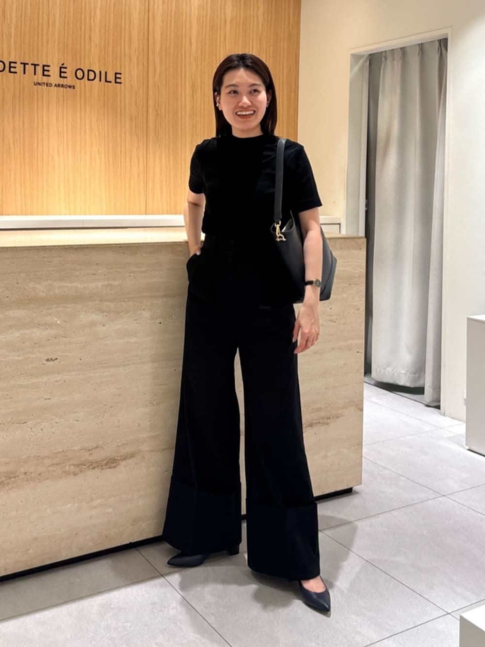 ブラック系のトートバッグ、ブルー系のパンプスを着用したレディースの秋コーディネートの1枚目の写真