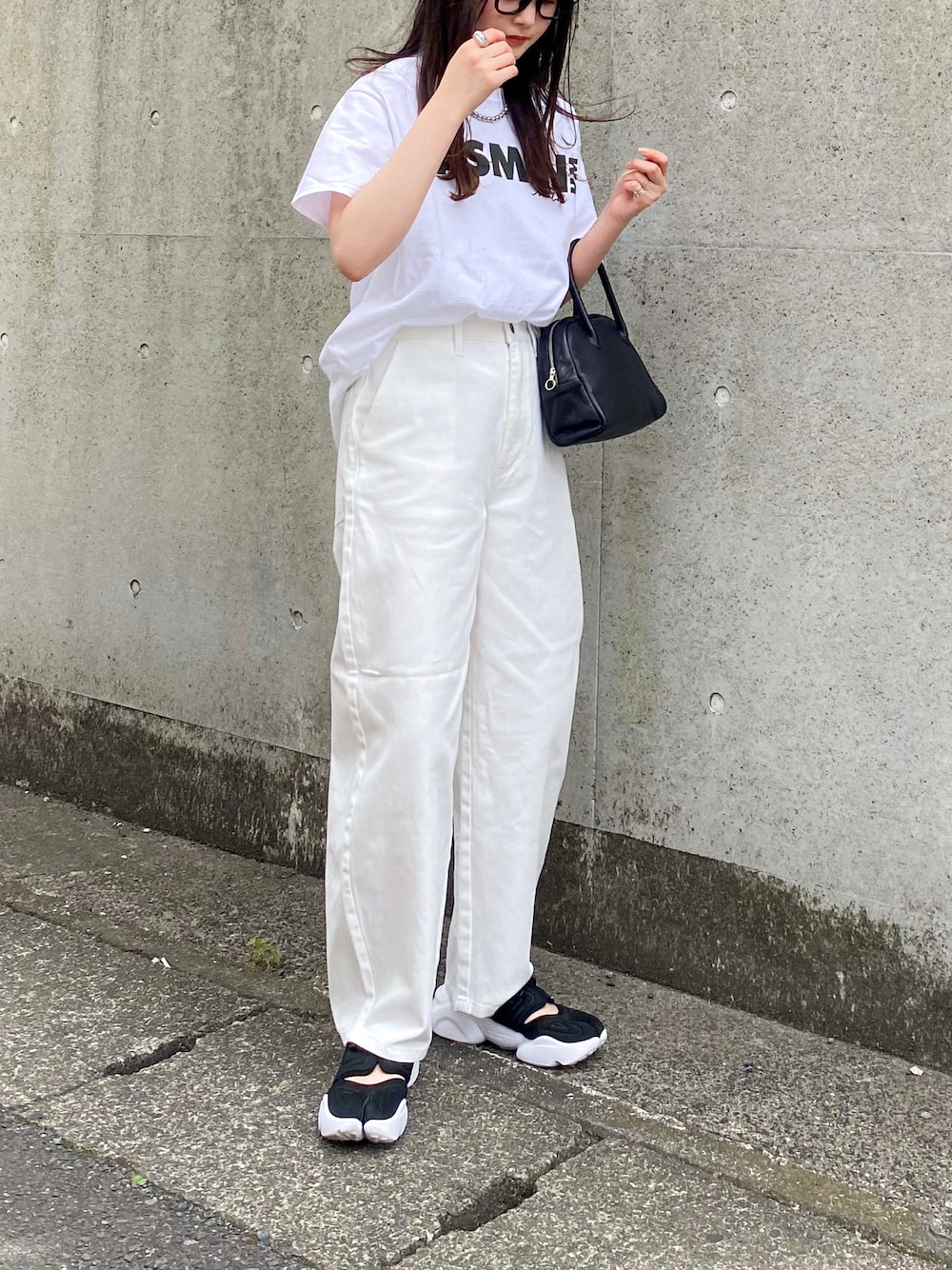 ホワイト系のTシャツ/カットソー、ホワイト系のデニムパンツ、ブラック系のショルダーバッグを着用したレディースの夏コーディネートの1枚目の写真