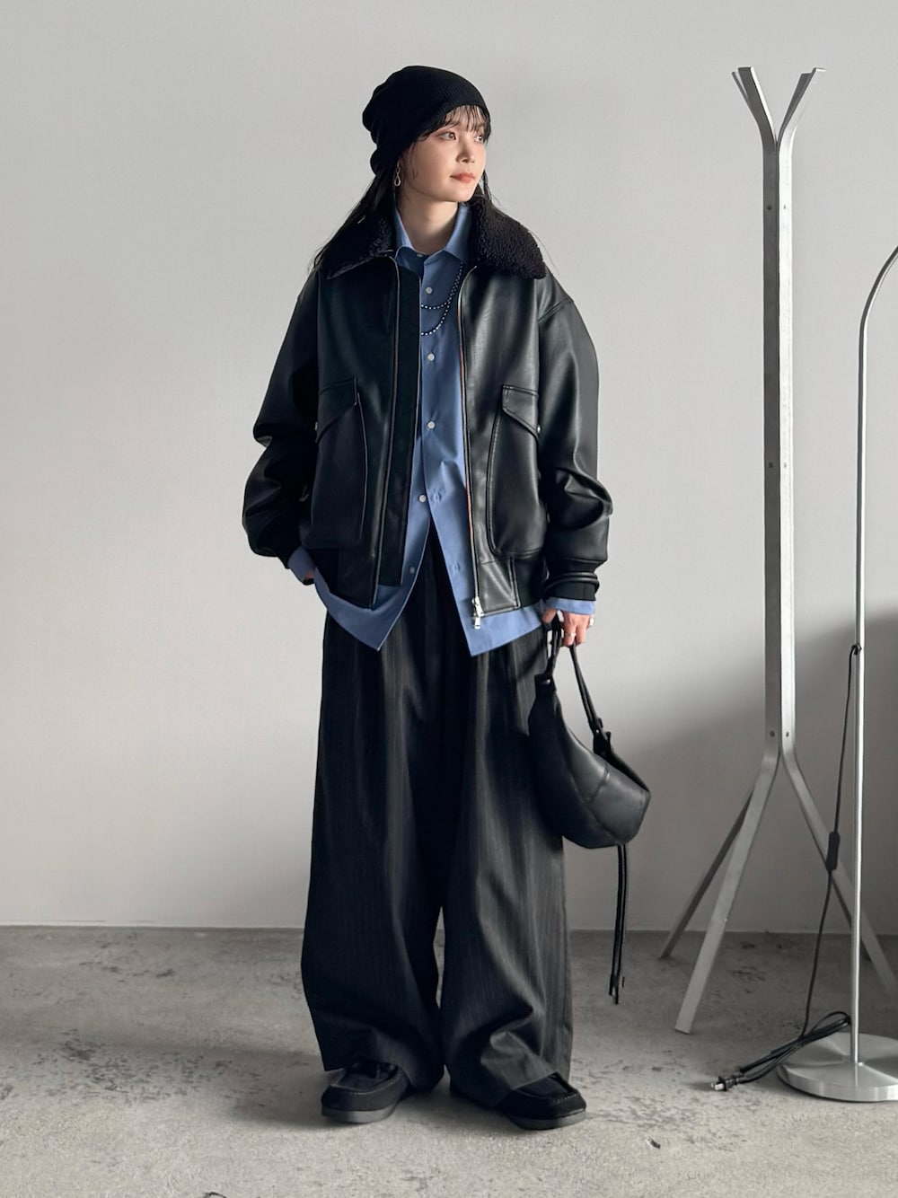 ブルー系のシャツ/ブラウス、ブラック系のブルゾン、グレー系のスラックスを着用したレディースの秋コーディネートの1枚目の写真