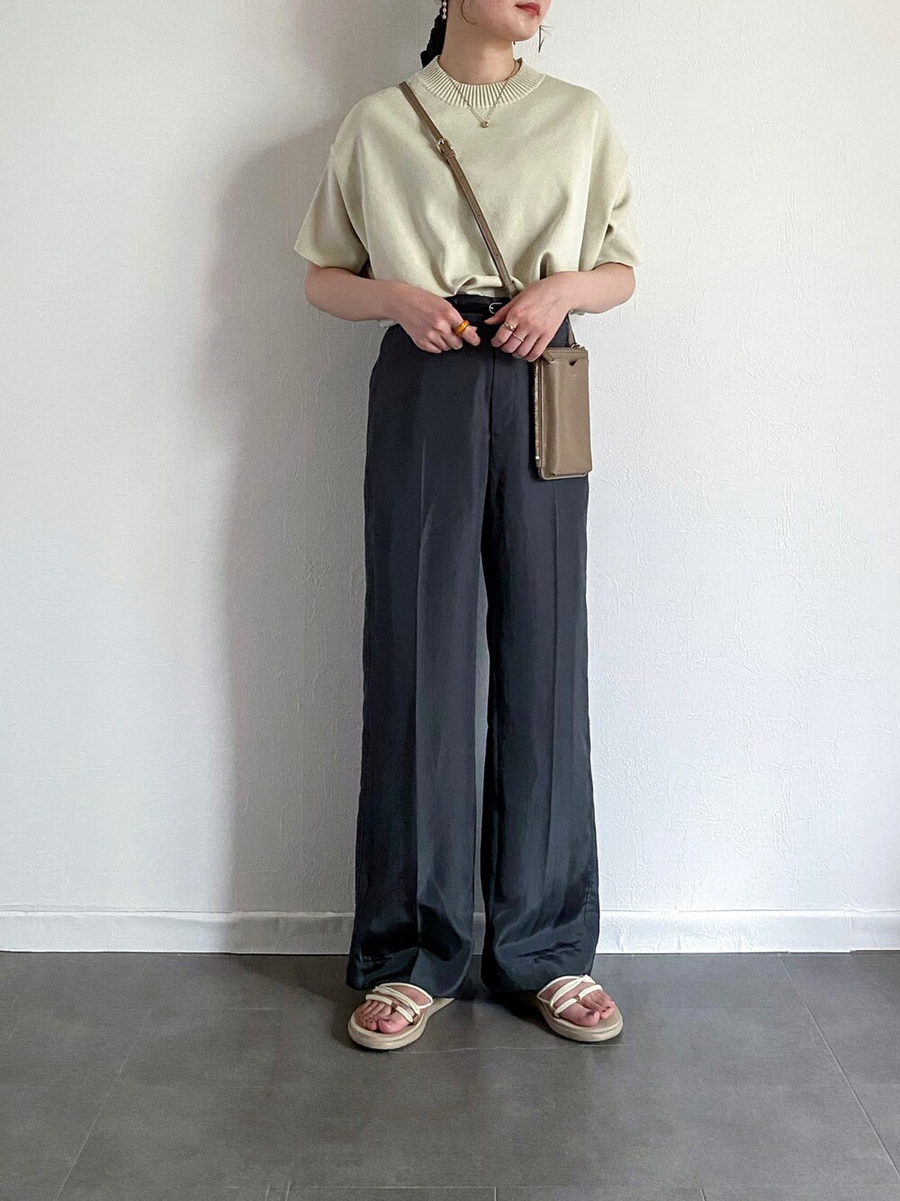 ホワイト系のニット/セーター、グレー系のその他パンツ、ベージュ系のショルダーバッグを着用したレディースの夏コーディネートの1枚目の写真