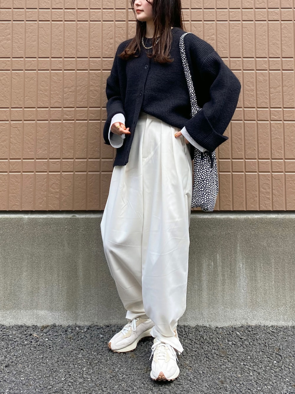 ブラック系のカーディガン/ボレロ、ホワイト系のTシャツ/カットソー、ホワイト系のスニーカーを着用したレディースの冬コーディネートの1枚目の写真