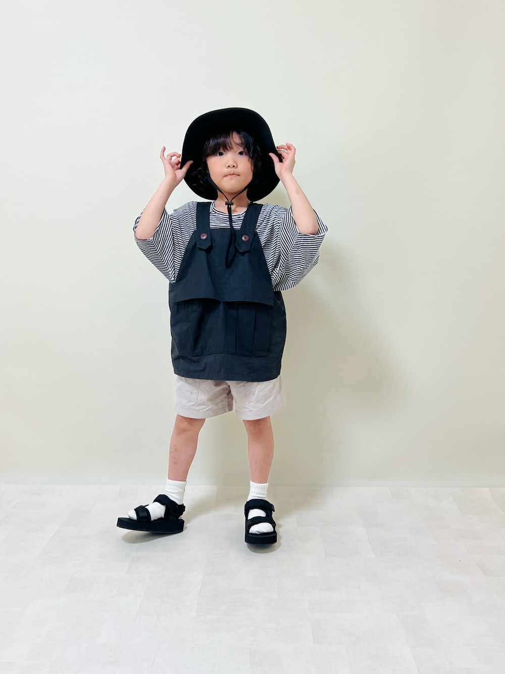 その他のサンダル、ブラック系のハットを着用したキッズの春コーディネートの1枚目の写真