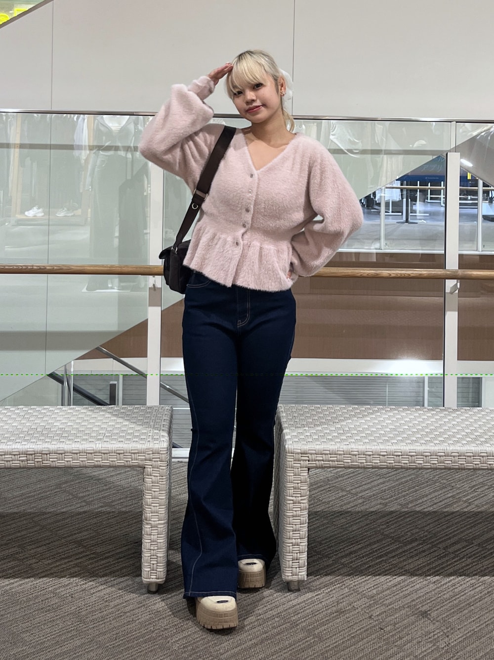 ブルー系のデニムパンツ、ブラウン系のショルダーバッグ、ピンク系のニット/セーターを着用したレディースの秋コーディネートの1枚目の写真