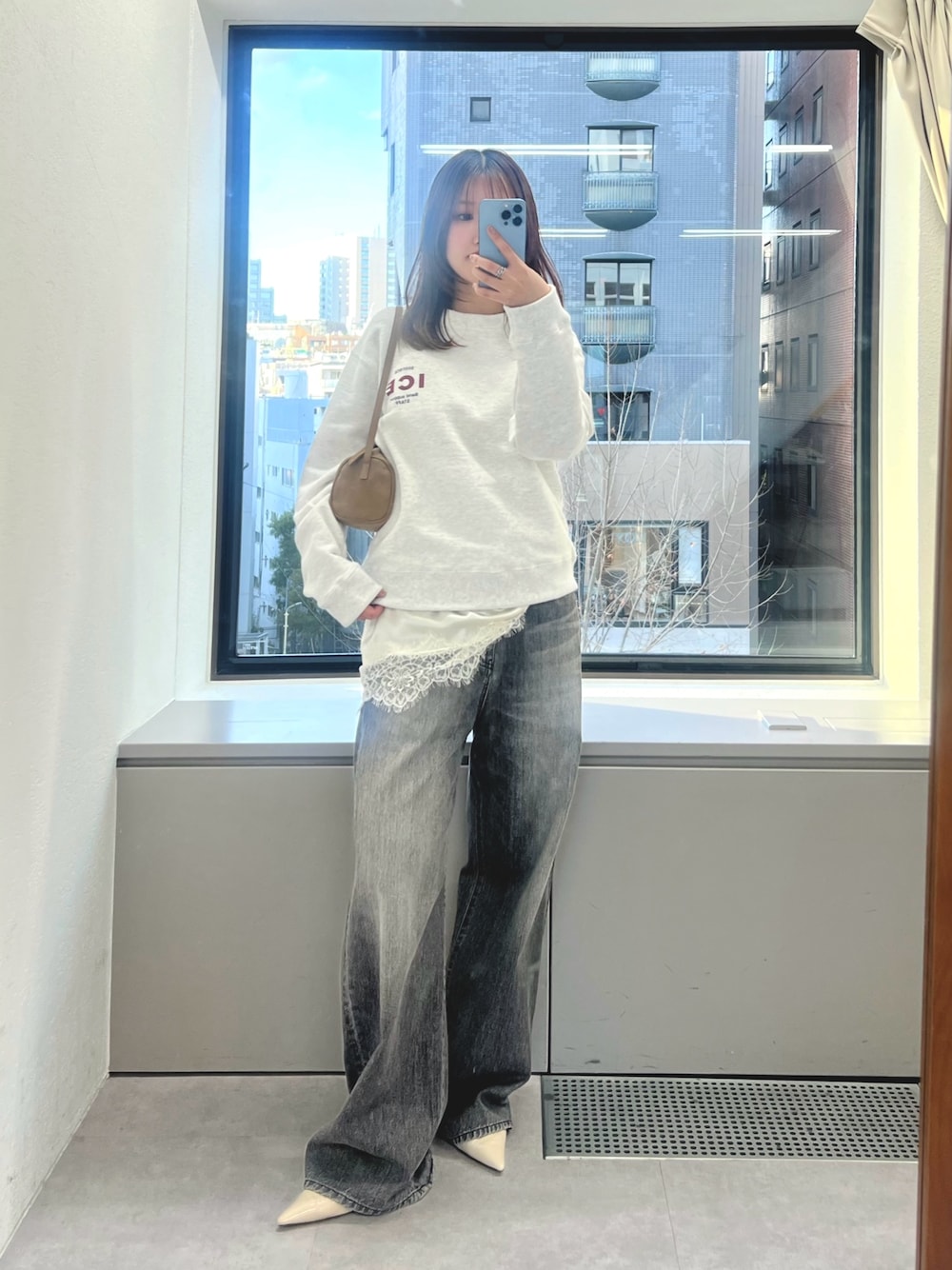 ホワイト系のキャミソール、グレー系のスウェット、グレー系のデニムパンツを着用したレディースの冬コーディネートの1枚目の写真