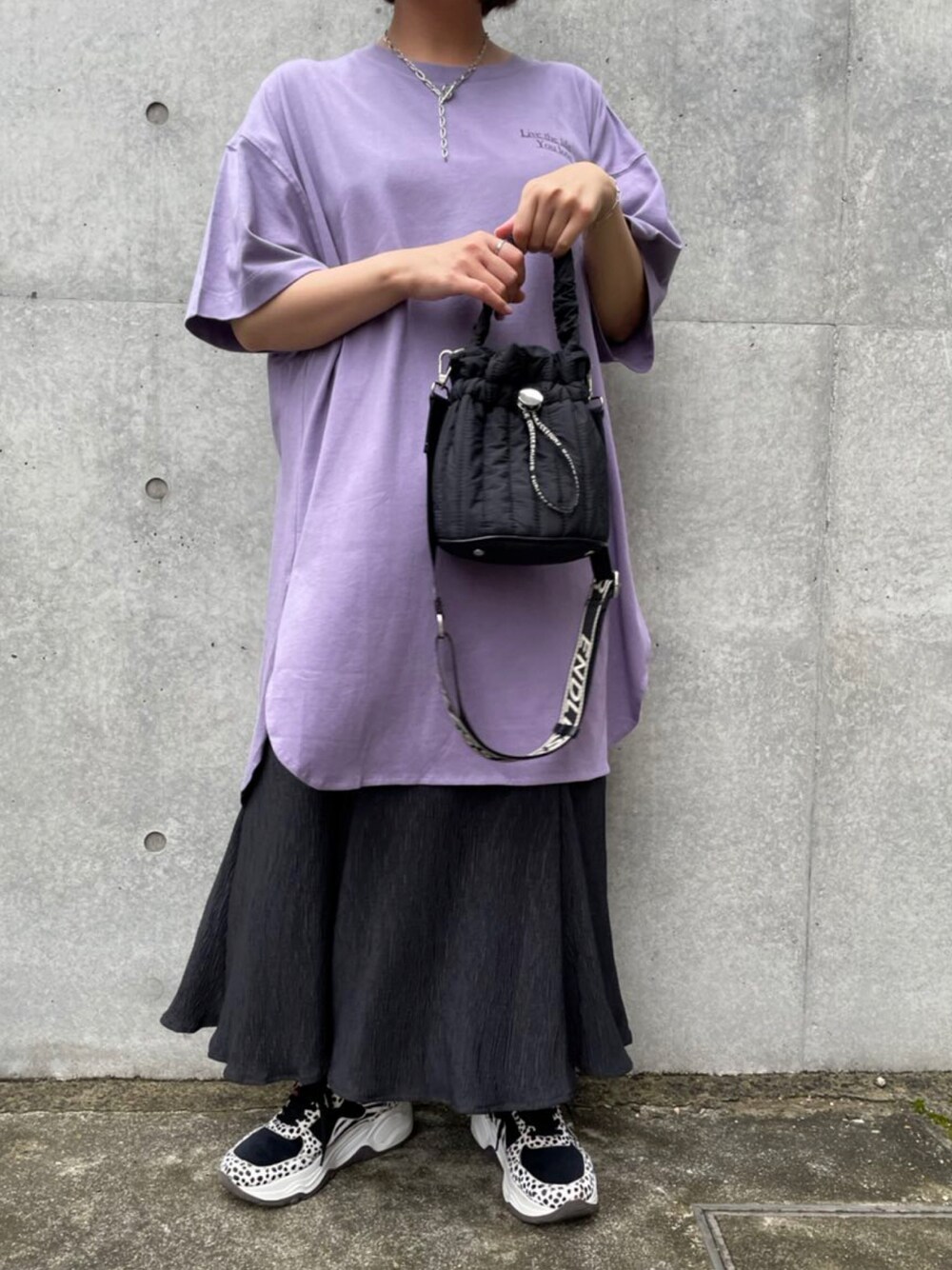 パープル系のTシャツ/カットソー、ブラック系のスカートを着用したレディースの秋コーディネートの1枚目の写真