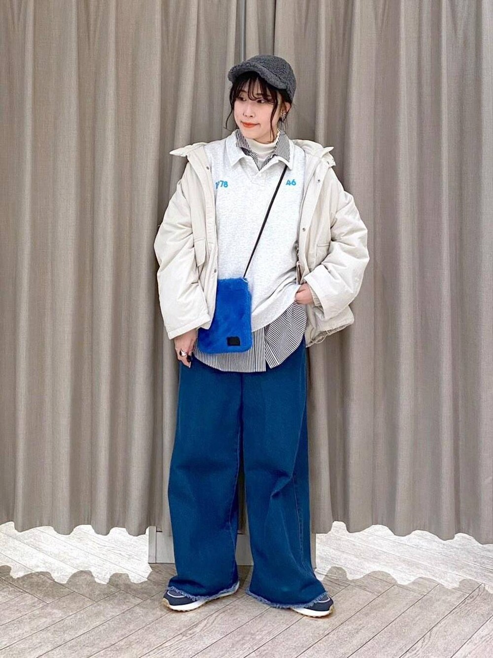 ホワイト系のTシャツ/カットソー、ベージュ系のブルゾン、ブルー系のデニムパンツを着用したレディースの秋コーディネートの1枚目の写真