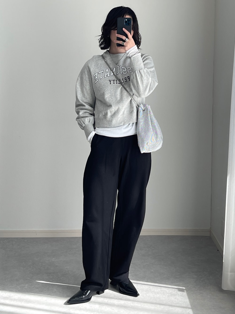 ブラック系のその他パンツ、ブラック系のパンプス、シルバー系のショルダーバッグを着用したレディースの春コーディネートの1枚目の写真