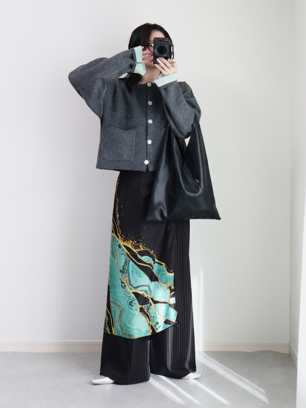 グレー系のカーディガン/ボレロ、ブラック系のスラックス、ブラック系のトートバッグを着用したレディースの秋コーディネートの1枚目の写真