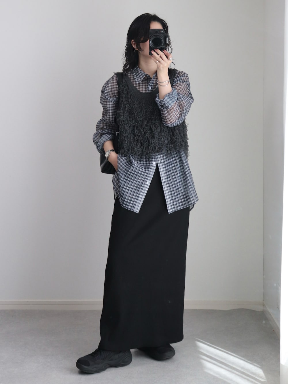 グレー系のベスト、ブラック系のシャツ/ブラウス、ブラック系のスカートを着用したレディースの秋コーディネートの1枚目の写真